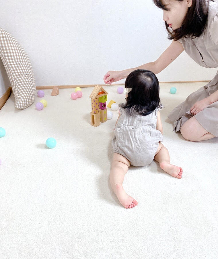 カーペットの上でお母さんと一緒に遊ぶ子供